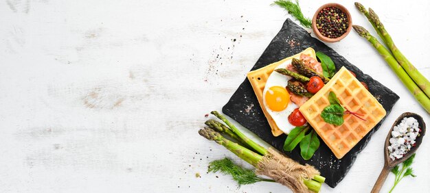 Breakfast Belgian waffles with egg asparagus and bacon Healthy food Top view Free space for your text