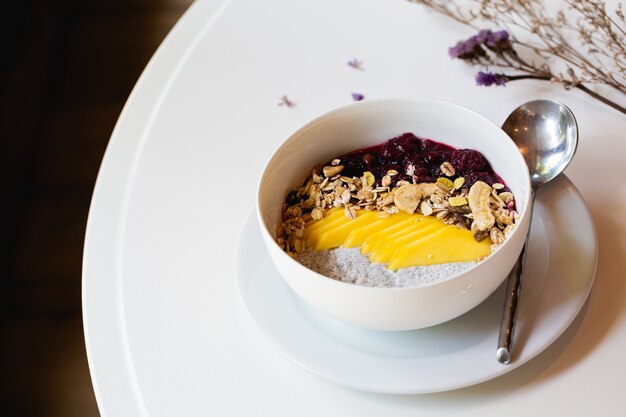 Breakfast berry smoothie bowl topped with blueberry,almond, banana and chia seeds.