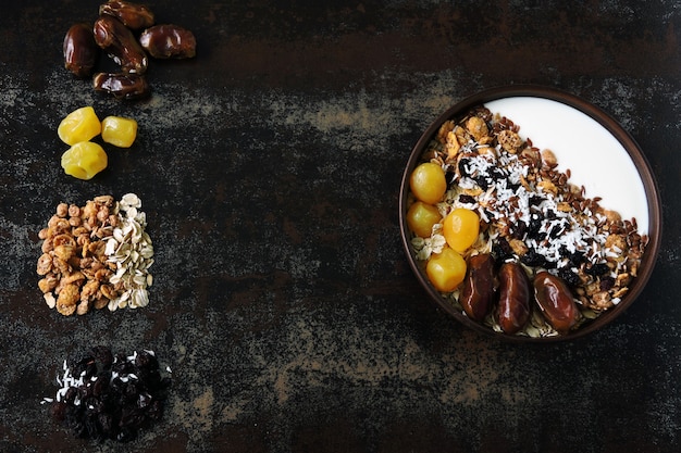 Breakfast bowl with greek yogurt, oatmeal, granola and dried fruit.