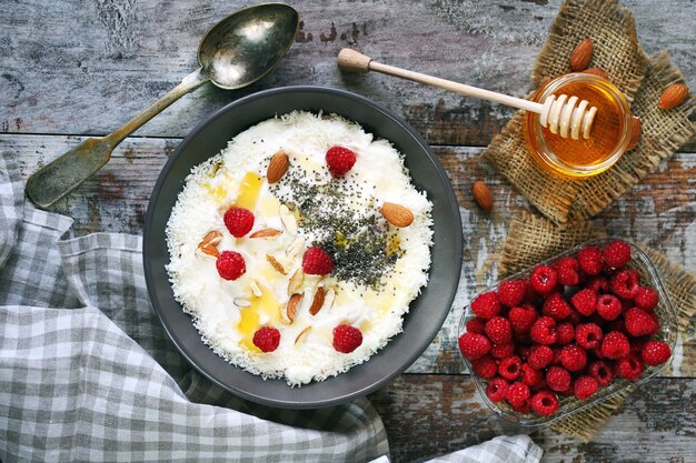Breakfast bowl with raspberries, honey and seeds.