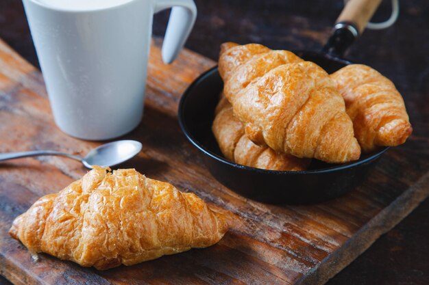 Breakfast bread croissants and fresh milk on the wooden table