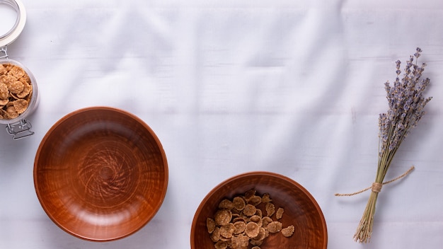 Breakfast cereal in clay bowls on a white tablecloth