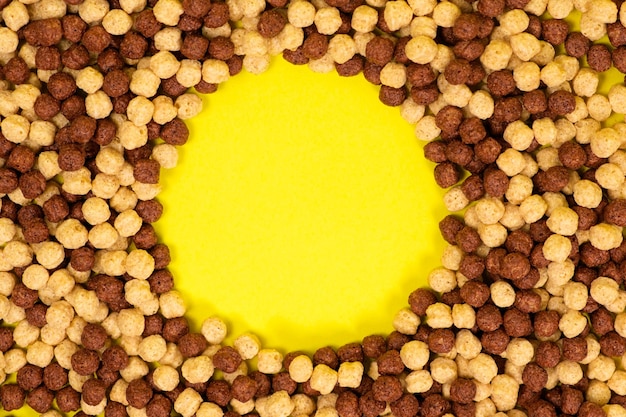 黄色の背景にココア ボールの形で朝食用シリアル
