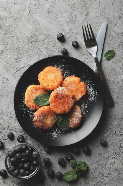 Foto colazione di frittelle di formaggio sulla superficie grigia