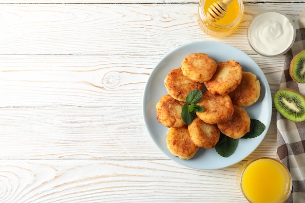 Breakfast of cheese pancakes on wooden surface