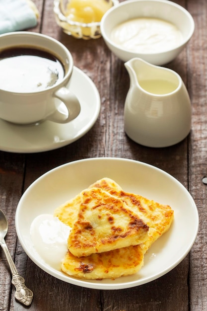 チーズケーキ、コーヒー、紅茶の朝食。珍しい三角形のチーズケーキ。