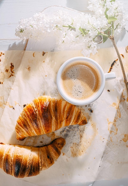 Breakfast concept hot and fresh croissant and a cup of coffee