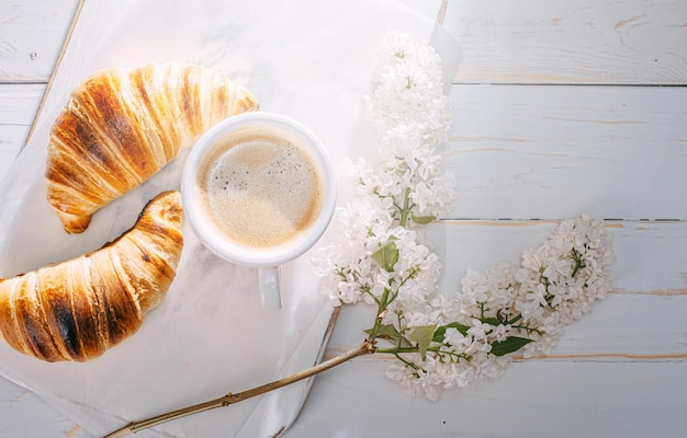 Breakfast concept hot and fresh croissant and a cup of coffee