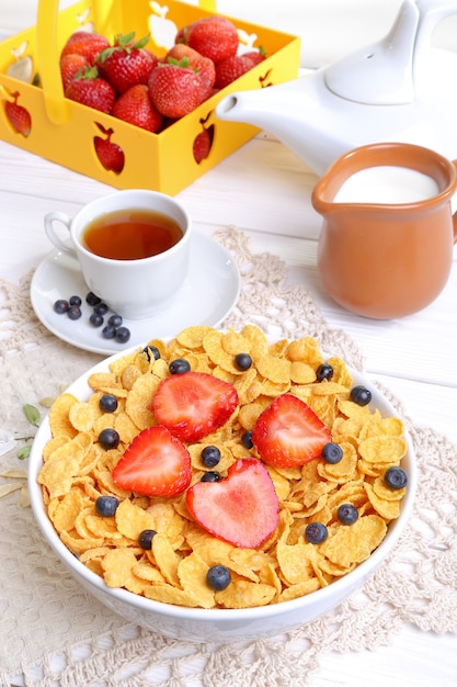 Colazione - cornflakes con latte, fragole e mirtilli