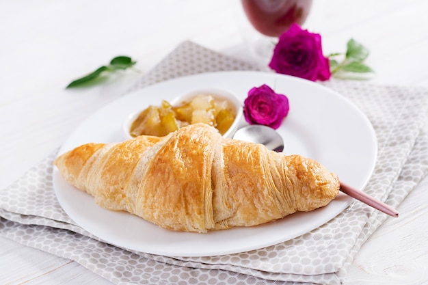 Breakfast - croissant, jam and coffee.