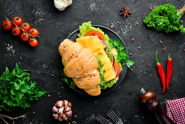 Breakfast croissant sandwich with cheese tomatoes and onions Top view Free space for your text