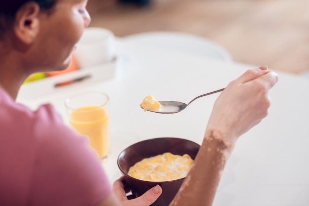 朝ごはん。家で朝食をとっている浅黒い肌の若い女性