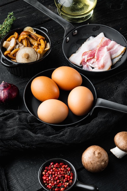 Photo breakfast egg ingredients mix, on black wooden table background