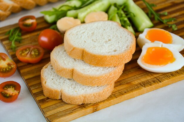 Breakfast of eggs, tomato, cucumber and bread