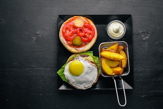 Breakfast French fries and burger with meat and egg On a wooden background Top view Free space