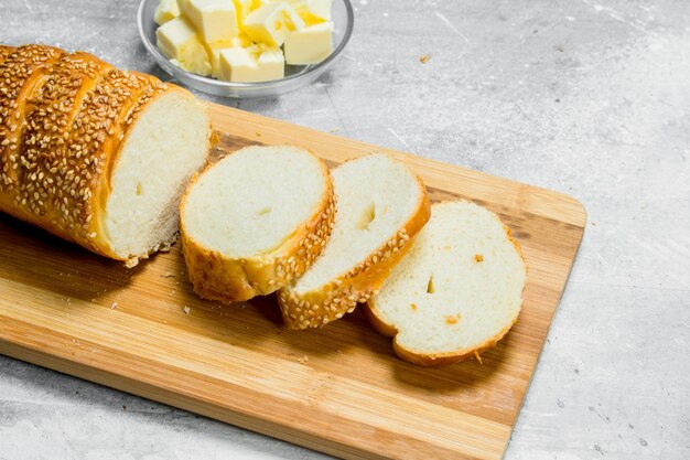 Photo breakfast fresh bread and butter on a wooden board