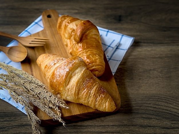 Photo breakfast fresh croissants decorated with wheat grass on wooden table