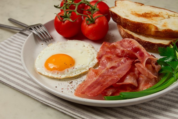 Breakfast fried egg bacon and bread with cherry on a light background homemade no people