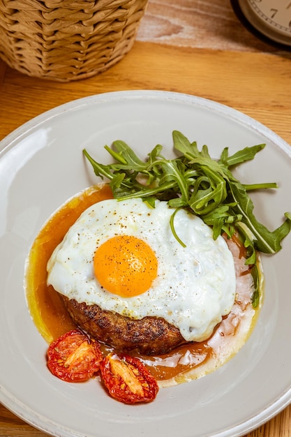 Foto colazione uova fritte con rucola bistecca e pomodori secchi