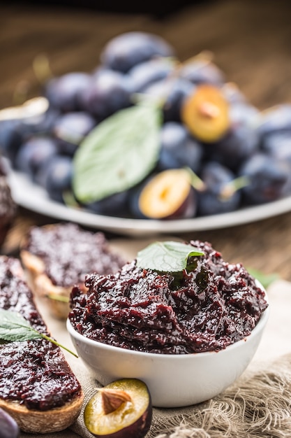 Colazione con pane fatto in casa con marmellata di prugne e prugne mature fresche.