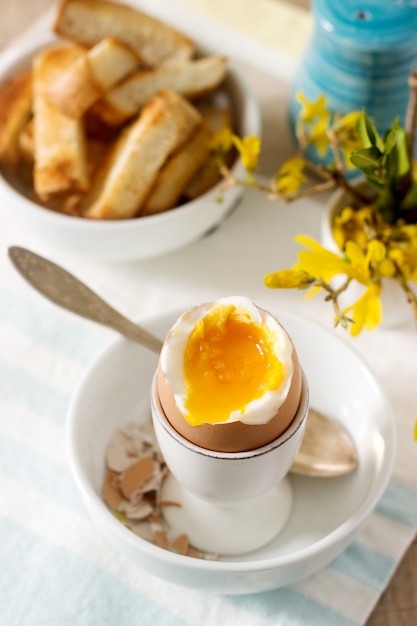 반숙 계란, 빵 토스트, 크림을 곁들인 커피 및 신선한 신문에서 아침 식사.