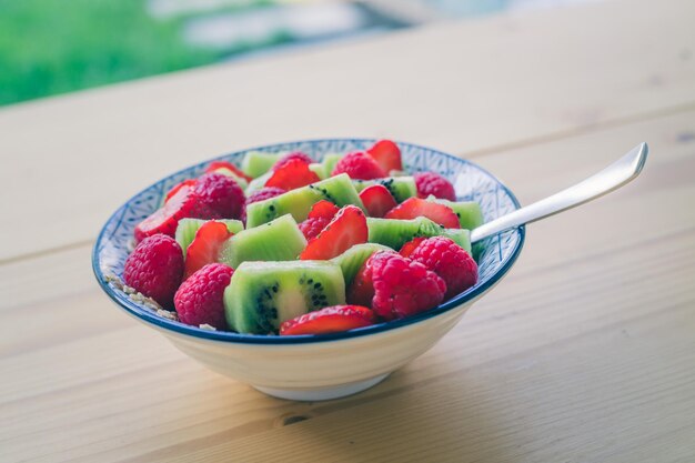 Ciotola di frutta per la colazione con fragole e kiwi da vicino stile di vita sano per i vegetariani