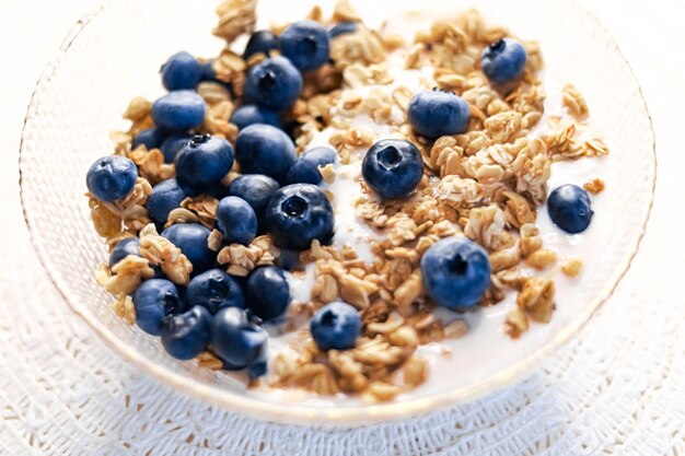 Foto idea per la colazione e cibo delizioso cereali per la colazione con yogurt senza lattosio e mirtilli biologici freschi in una ciotola ricetta gustosa e salutare