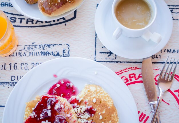 Breakfast including pancakes with raspberry jam