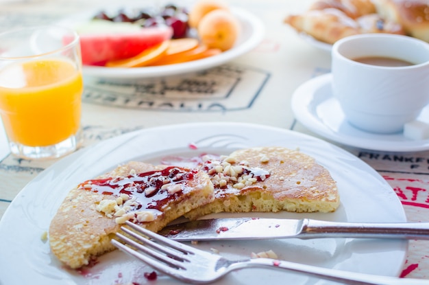 Breakfast including pancakes with raspberry jam