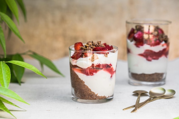 Breakfast layered parfait dessert with yogurt sponge biscuit and fresh strawberry white background copy space