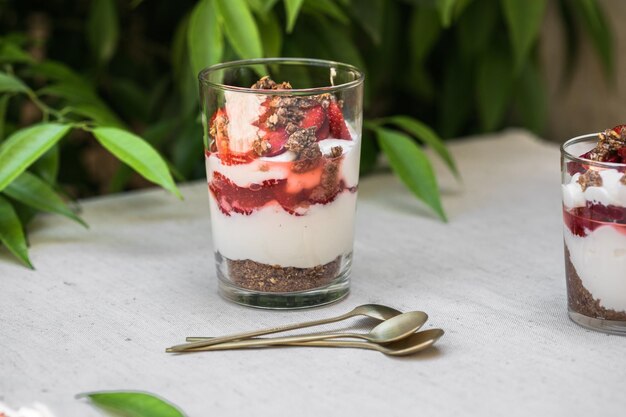 Breakfast layered parfait dessert with yogurt sponge biscuit and fresh strawberry white background copy space