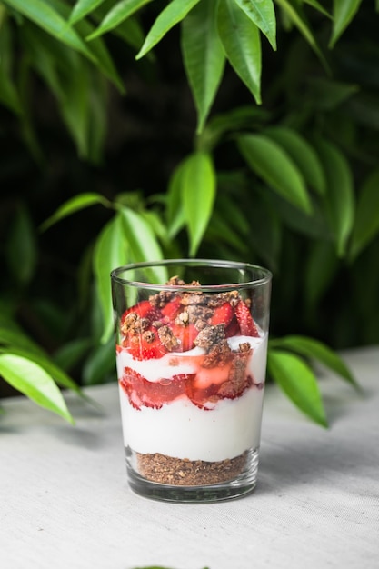 Breakfast layered parfait dessert with yogurt sponge biscuit and fresh strawberry white background copy space