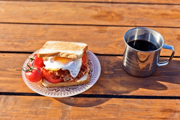자연 속에서의 아침 식사 베이컨 튀김 토스트와 보온병의 따뜻한 커피를 곁들인 계란 후라이