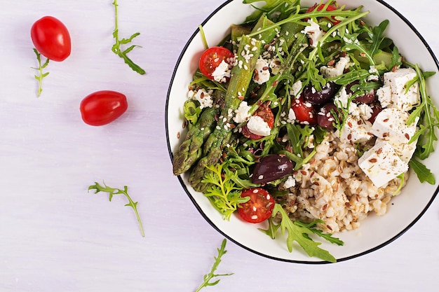 Breakfast oatmeal porridge with feta cheese cherry tomatoes asparagus and arugula Healthy balanced food Top view overhead