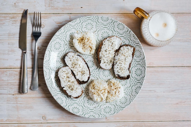 Foto colazione su un piatto uova in camicia e panini al formaggio