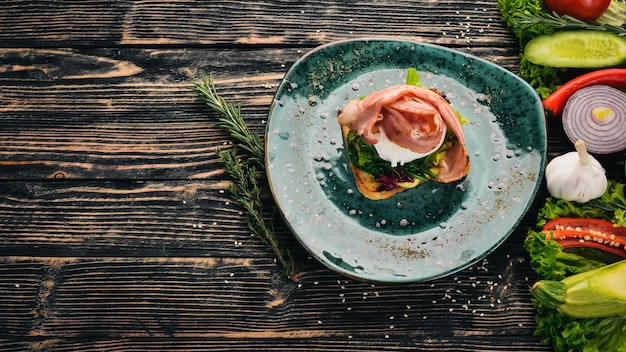 Breakfast Poached egg bacon on lettuce made from toast On a black wooden background Copy space