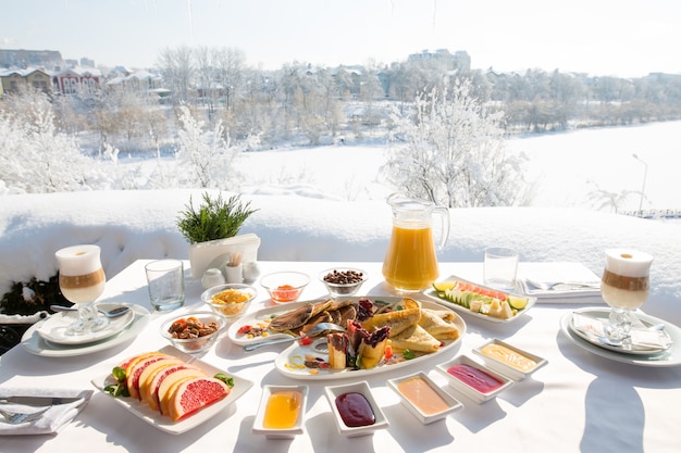 雪の降る冬の屋外でレストランで朝食をとります。