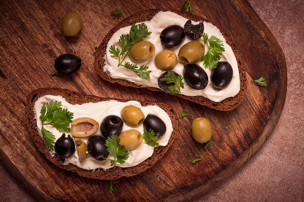 Foto sandwich per la colazione con olive al formaggio a crema vista dall'alto