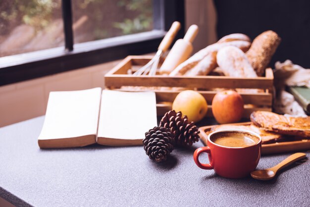 Breakfast scene with coffee cup, bread and fruits on the table 