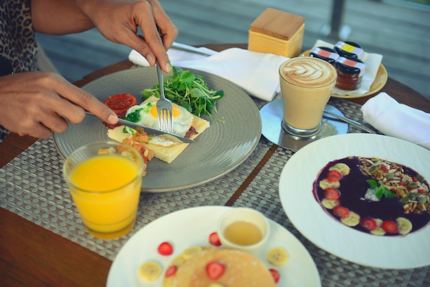 Breakfast served with fried egg, coffee, orange juice, cereals and fruits for healthy.