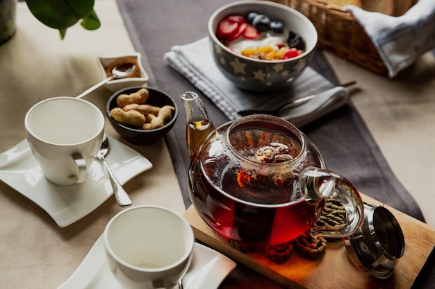 Breakfast set oatmeal with berries and black tea with rose flowers