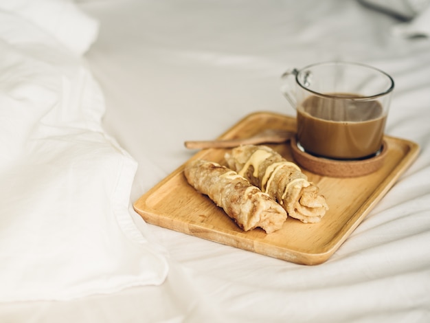 Breakfast set of roti and hot cocoa served on bed.