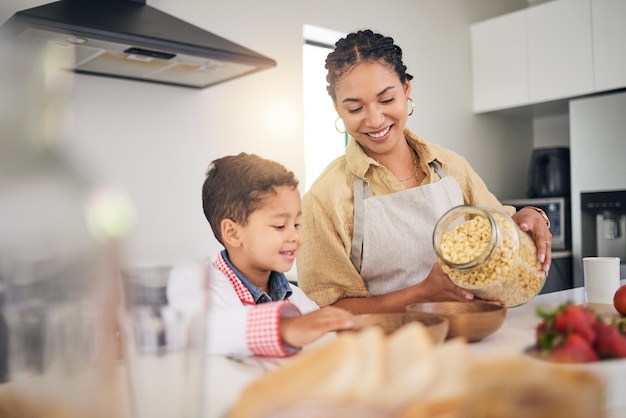 Breakfast smile and a mother and child cooking baking or helping with food in the kitchen House eating and a boy kid and a young mom teaching during lunch or for dinner together while hungry