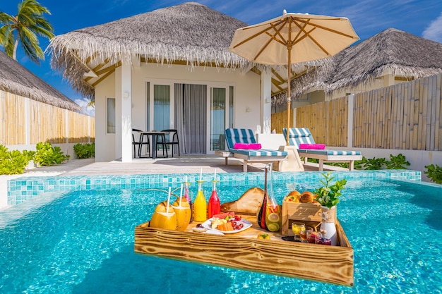 Breakfast in swimming pool, floating breakfast table in luxury tropical resort. Beach villa chairs