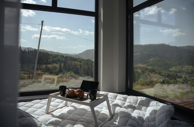 Breakfast table on a bed with panoramic mountain view