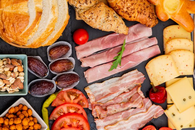 Colazione sul tavolo. colazione a base di croissant, cereali, pancetta, prosciutto, formaggio, lattuga, fagioli, fiocchi di mais, frutta, caffè, tè e succo d'arancia. , pranzo o cena per tutti i giorni