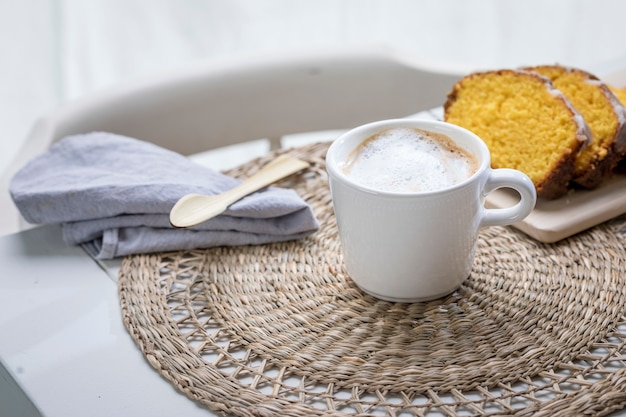 Breakfast on the table, cup with latte and pudding