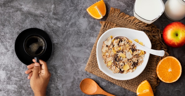 Photo breakfast table with human hand holding coffee cup.