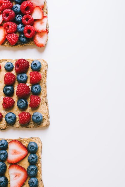 Breakfast toasts with whole grain bread peanut butter raspberry strawberry and blueberry