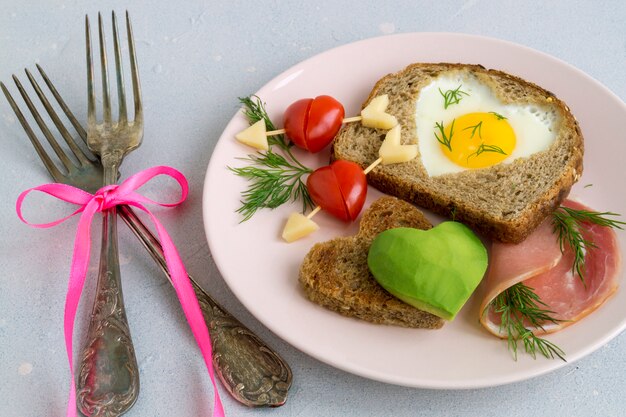 Breakfast for Valentine's day. egg and toast in the shape of a heart.